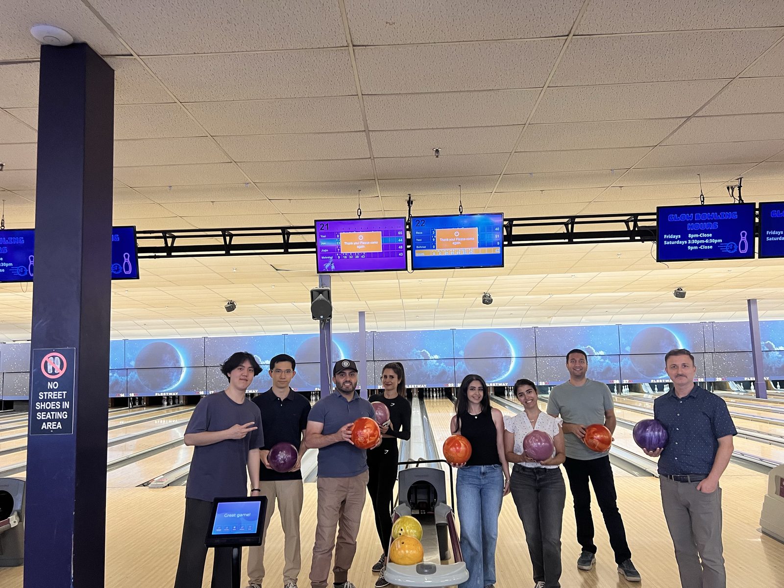 Lab members standing with bowling balls at a bowling alley